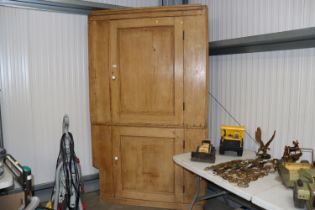 An antique stripped pine floor standing corner cup