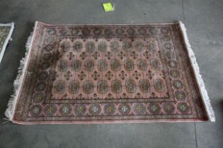 An approx 6' x 4' pink patterned rug