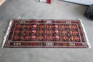 An approx 6' x 2'6" patterned rug