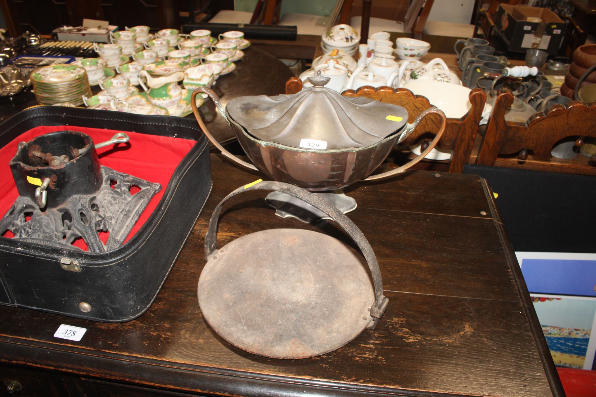 A plated soup tureen; an iron skillet and a cast i