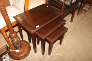 A nest of modern mahogany coffee tables; an Edward