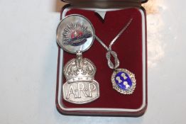 A silver ARP badge; an Australia Forces badge; and