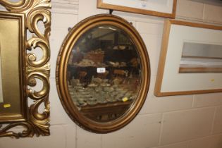 An oval gilt framed wall mirror