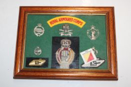 A framed and glazed collection of Royal Armoured Corps badges