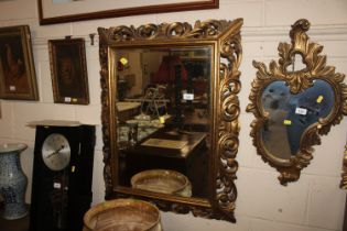 An ornate gilt framed bevel edged wall mirror