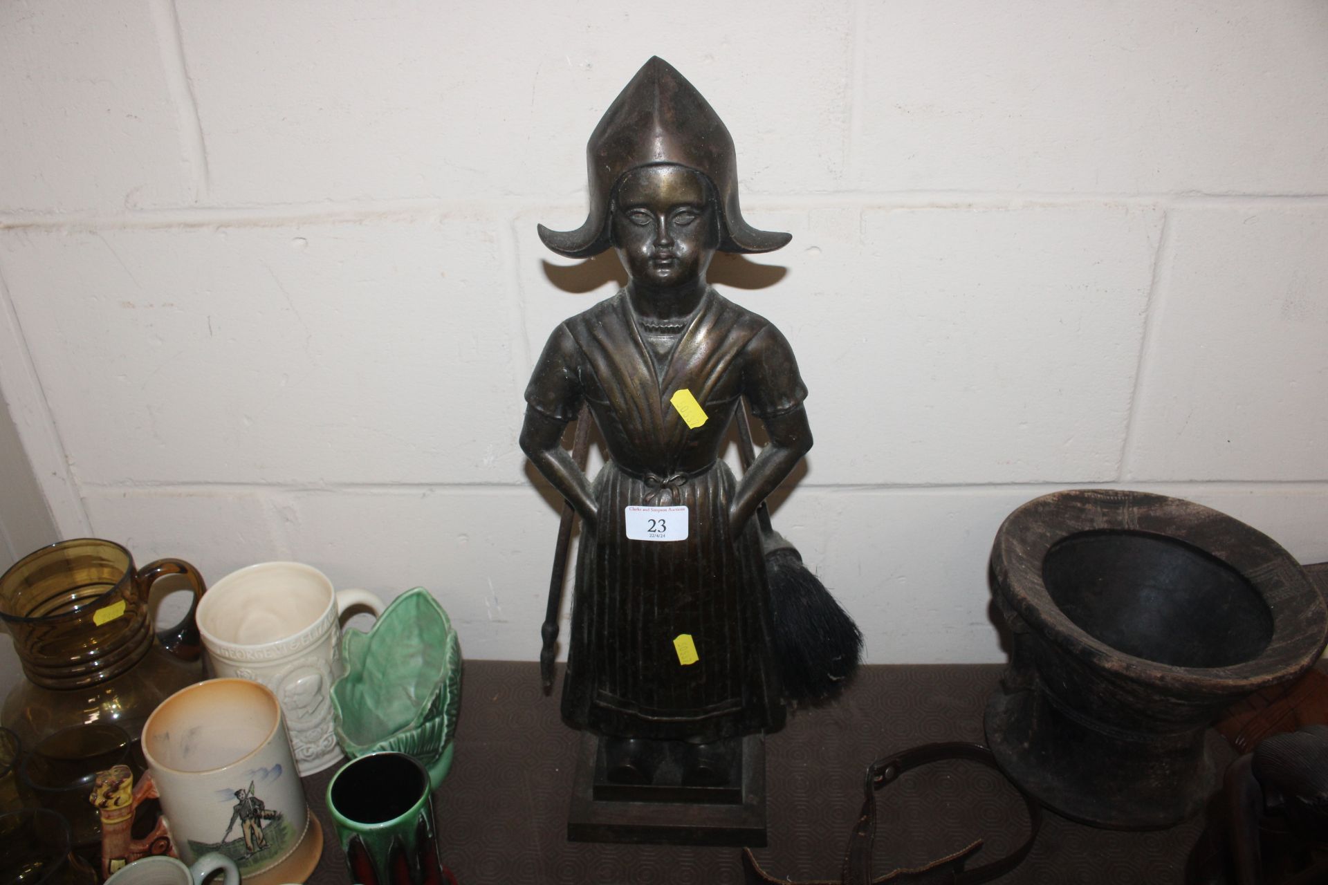 A bronzed hearth companion stand in the form of a Dutch girl