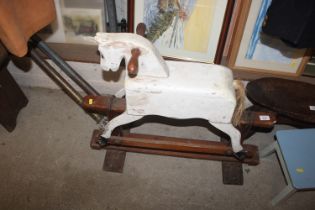 A small painted wooden rocking horse on stand