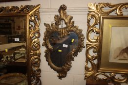 A gilt framed cartouche shaped wall mirror