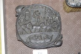 An antique carved plaque depicting castle and figures