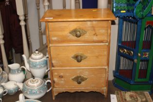 A small pine three drawer miniature chest of drawe