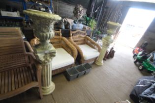 A pair of ornate styled resin urns on column bases