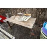 A wooden trestle table and three folding garden ch