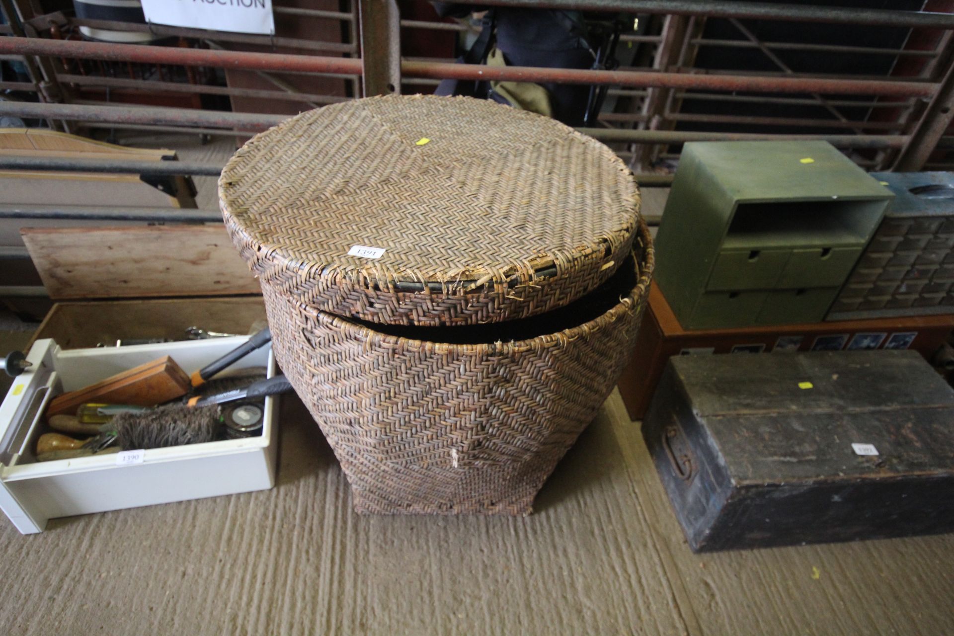 A large circular wicker basket with lid