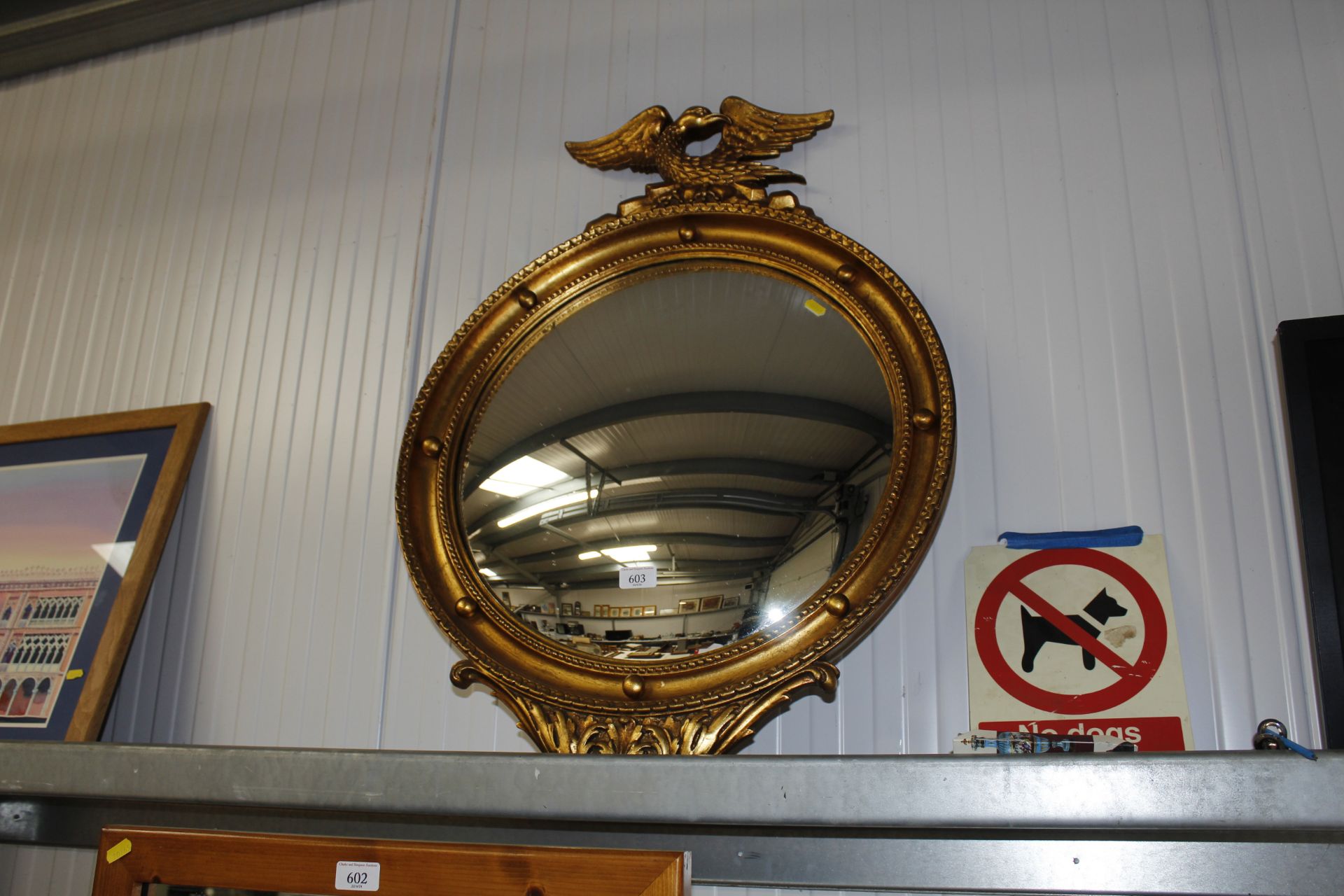 A circular gilt framed convex wall mirror