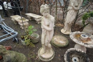 A painted concrete statue in the form of a scantily clad robed maiden set to a plinth measuring