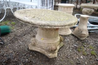 An ornate painted concrete garden table set onto a