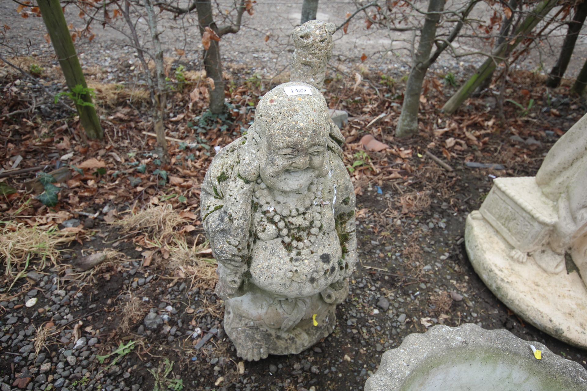 A concrete garden ornament in the form of a Buda