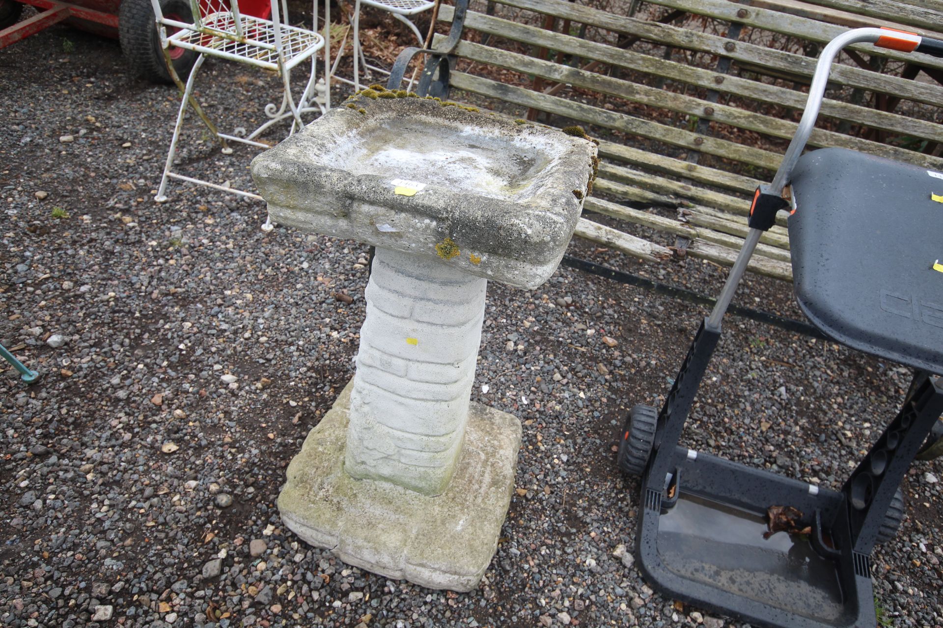 A concrete bird bath raised on plinth base AF