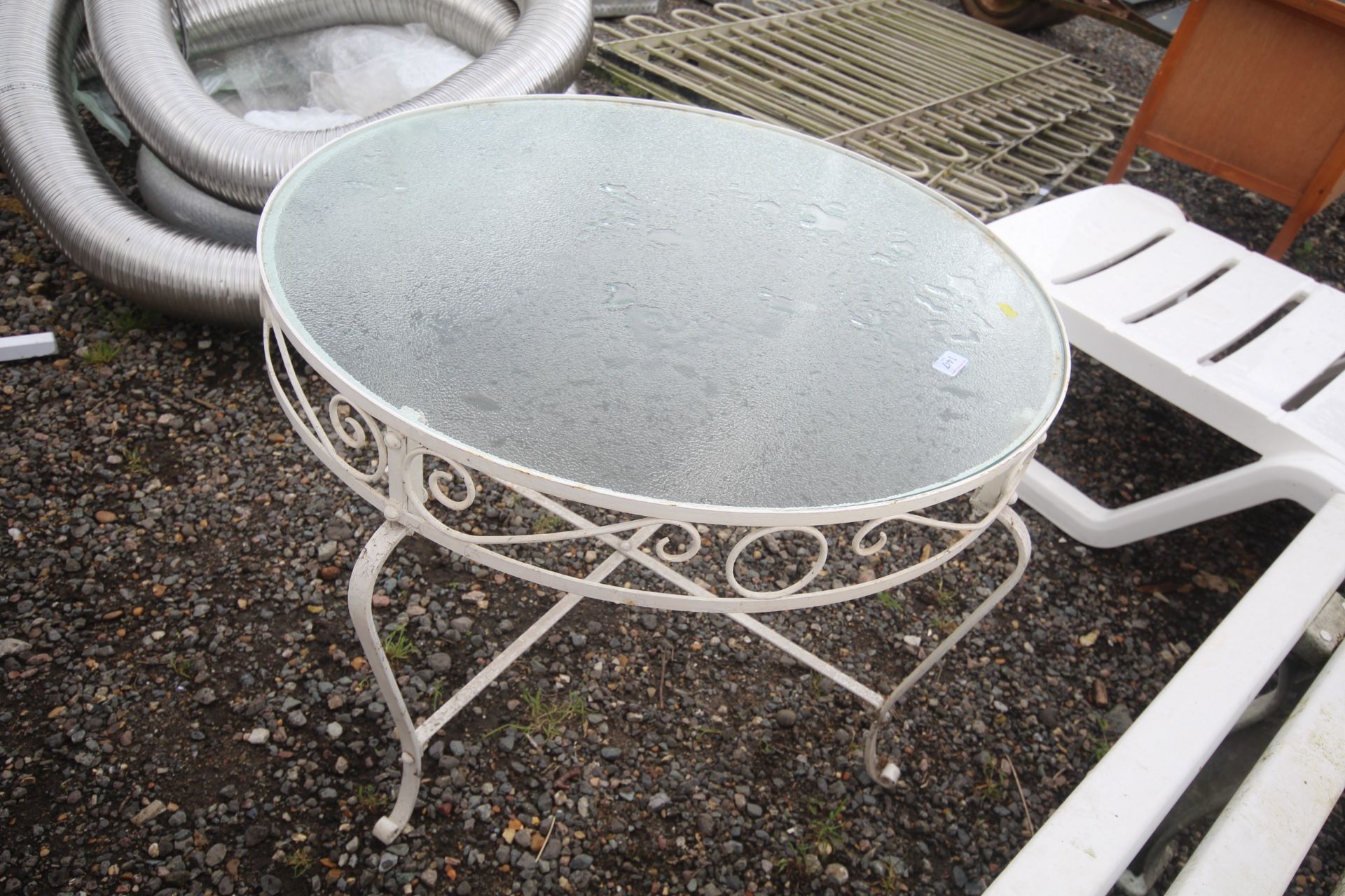 A circular wrought metal garden table with glass t - Image 2 of 2
