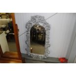 An ornate wall mirror with Cherub decoration and bevel plate