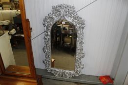 An ornate wall mirror with Cherub decoration and bevel plate