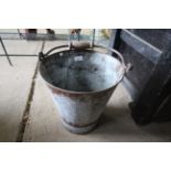 A galvanised bucket with wooden and metal swing ha