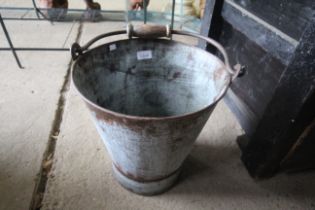 A galvanised bucket with wooden and metal swing ha