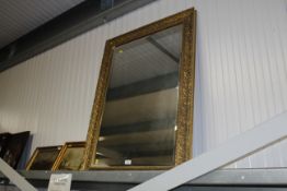 An ornate gilt framed and bevel edged wall mirror