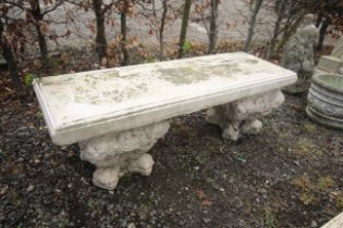 A painted concrete garden bench raised upon a pair