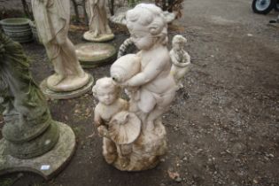 A painted concrete water feature of two Cherub for