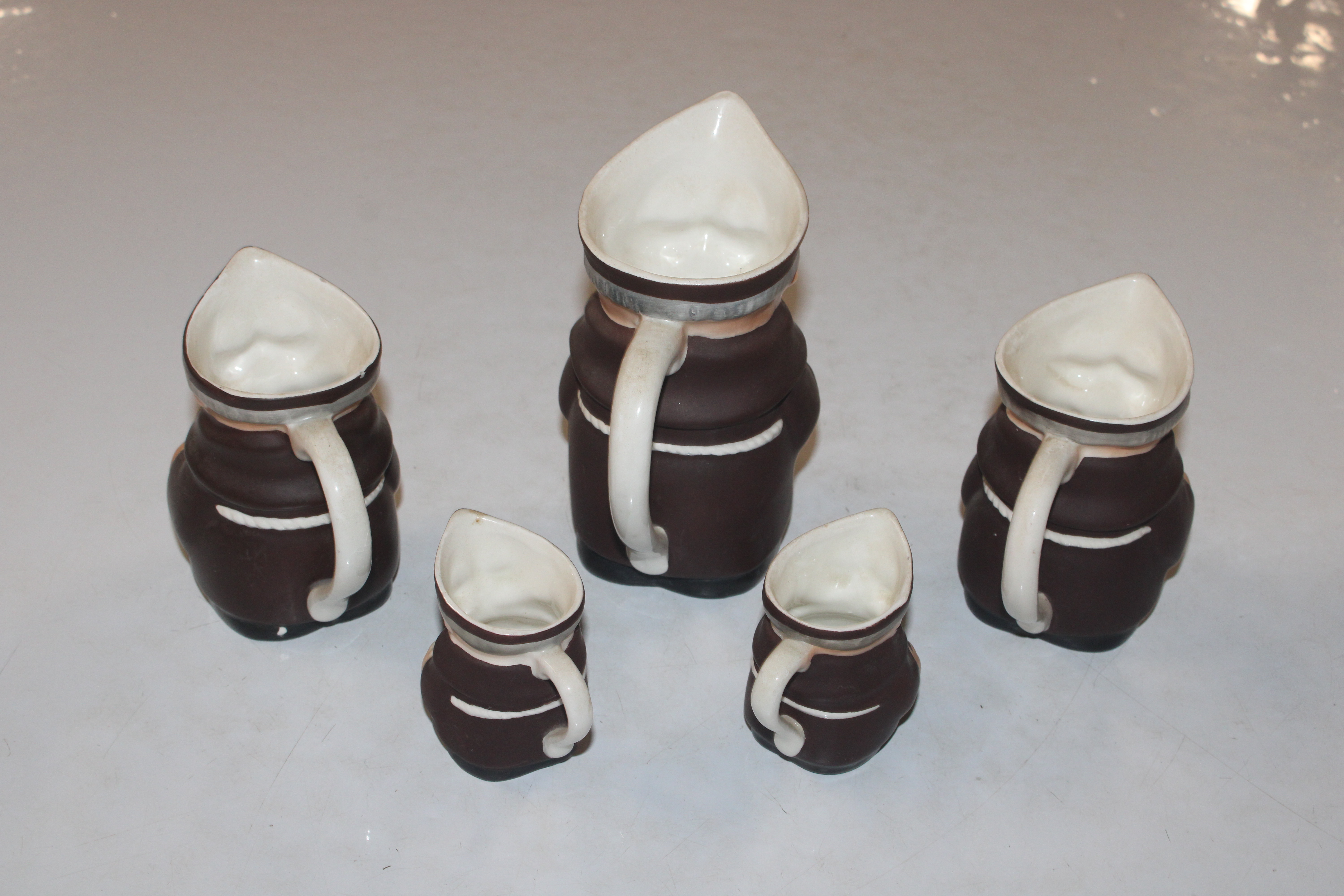 Five graduated jugs in the form of monks; and a de - Image 3 of 9