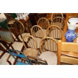 Seven blonde Ercol stick back kitchen chairs, six