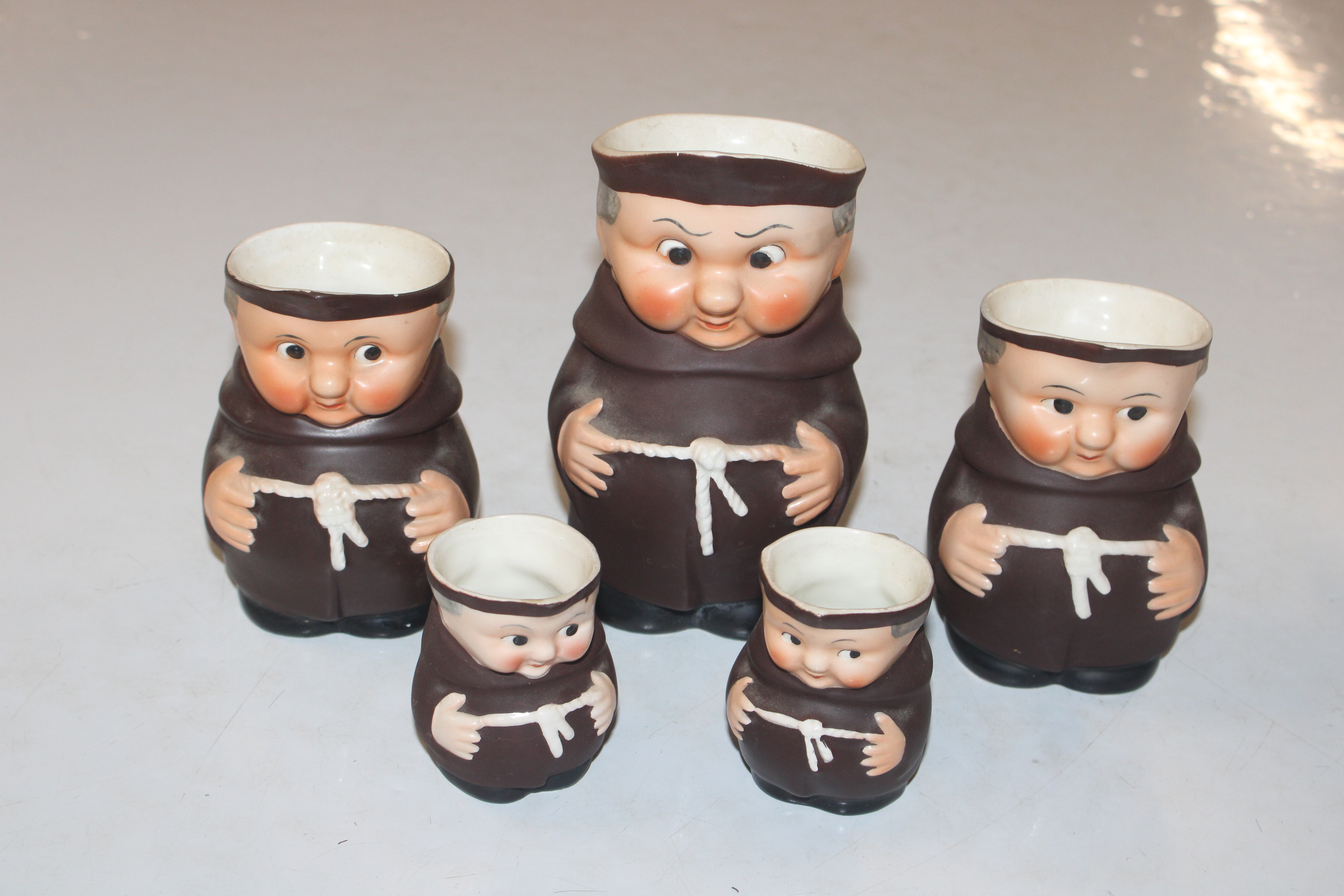 Five graduated jugs in the form of monks; and a de - Image 2 of 9