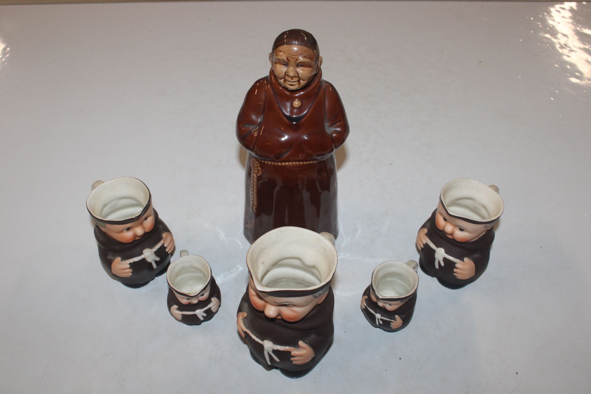 Five graduated jugs in the form of monks; and a de