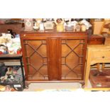 A mahogany bookcase enclosed by astragal glazed do