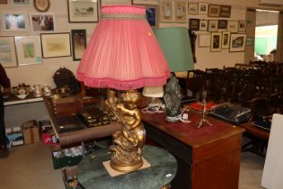 A large gilt table lamp with pink pleated shade