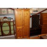 A modern stripped pine hanging wardrobe