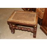 A walnut framed stool with cane seat