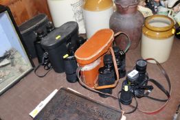 Three pairs of cased binoculars and another pair