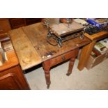 An antique pine drop leaf kitchen table fitted end