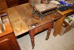 An antique pine drop leaf kitchen table fitted end