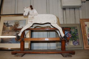 A small painted wooden rocking horse on stand
