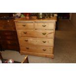 An antique stripped pine chest of two short and th