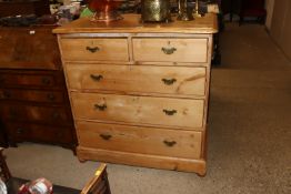 An antique stripped pine chest of two short and th