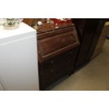 An oak bureau fitted three drawers