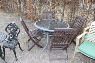 A glass topped circular table and set of four fold