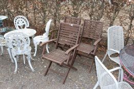 Three varnished wooden folding garden armchairs