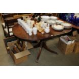 A reproduction mahogany drop leaf dining table and