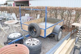 A single axle car trailer with spare tyres, front