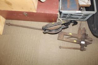 A large metal leg vice and metal hook on pulley wh